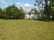 Lush backyard with a view of the home and surrounding trees, offering a peaceful outdoor space at 5701 Brackenwood Dr, Spring Hill, FL 34609