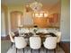 Elegant dining room with stylish chandelier, a marble table setting for six and a view to the kitchen at 5701 Brackenwood Dr, Spring Hill, FL 34609