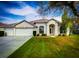 Charming single-story home with well-manicured lawn, a three-car garage, and an inviting front entrance at 5701 Brackenwood Dr, Spring Hill, FL 34609
