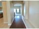 Hallway with hardwood floors leads to a carpeted room, creating a smooth transition within the home at 5701 Brackenwood Dr, Spring Hill, FL 34609