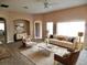 Bright living room with neutral furniture, a ceiling fan, an area rug, and large windows overlooking the backyard at 5701 Brackenwood Dr, Spring Hill, FL 34609