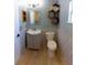 Well-lit bathroom featuring a modern vanity, toilet, and unique decorative shelving at 6172 Raleigh St, Spring Hill, FL 34606