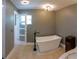 Modern bathroom featuring a freestanding tub, stylish lighting, and tiled floors at 6172 Raleigh St, Spring Hill, FL 34606