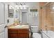 Bright bathroom featuring a granite vanity, decorative mirror, and shower with warm tile surround at 6315 Shane Ln, New Port Richey, FL 34653