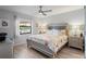 Bright bedroom with a floral patterned comforter, a ceiling fan, and windows offering views of the outdoors at 6315 Shane Ln, New Port Richey, FL 34653