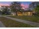 A charming home with a well-manicured lawn and beautiful outdoor lighting at twilight at 6315 Shane Ln, New Port Richey, FL 34653