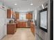 Well-lit kitchen with stainless steel appliances, tiled floors, wood cabinets, and granite countertops at 6315 Shane Ln, New Port Richey, FL 34653