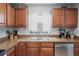 Close-up of a kitchen sink area with wood cabinets, tile backsplash, and modern fixtures at 6315 Shane Ln, New Port Richey, FL 34653