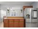 Shows the kitchen counter and cabinet, with a view to the dining room, and stainless steel refrigerator at 6315 Shane Ln, New Port Richey, FL 34653