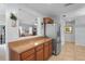 Shows the kitchen counter and cabinet, with a view to the living room, and stainless steel refrigerator at 6315 Shane Ln, New Port Richey, FL 34653