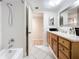 Bright bathroom with tub and shower combination, wood cabinets, white countertops, and tile flooring at 700 Starkey Rd # 622, Largo, FL 33771