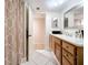 Well-lit bathroom featuring wood cabinets, white countertops, and a shower with a patterned curtain at 700 Starkey Rd # 622, Largo, FL 33771