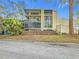 Beige condo building with screened patios surrounded by lush landscaping and trees against a blue sky at 700 Starkey Rd # 622, Largo, FL 33771