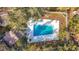 Aerial view of fenced community pool with lounge chairs surrounded by mature trees offering shade at 700 Starkey Rd # 622, Largo, FL 33771