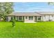 Well-maintained backyard with lush green grass and rear view of the home's exterior at 7392 Willow Brook Dr, Spring Hill, FL 34606