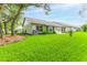 Lush backyard featuring a well-manicured lawn and mature trees surrounding the home at 7392 Willow Brook Dr, Spring Hill, FL 34606