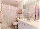 Traditional bathroom with a floral shower curtain, white fixtures, and classic wallpaper at 7392 Willow Brook Dr, Spring Hill, FL 34606