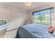 Comfortable bedroom with a large window, closet, blue bedding, and light-colored carpet at 7392 Willow Brook Dr, Spring Hill, FL 34606