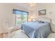 Cozy bedroom featuring a white wicker bed frame, blue quilt, and a window with blue valance at 7392 Willow Brook Dr, Spring Hill, FL 34606