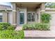 Inviting front entrance featuring a blue door and attractive landscaping at 7392 Willow Brook Dr, Spring Hill, FL 34606