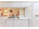 Kitchen sink area with white cabinets and appliances, open to the living room at 7392 Willow Brook Dr, Spring Hill, FL 34606