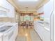Bright kitchen featuring white cabinetry and appliances, open to a dining area with natural light at 7392 Willow Brook Dr, Spring Hill, FL 34606