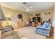 Spacious living room with a ceiling fan, comfortable furniture, entertainment center, and a light colored carpet at 7392 Willow Brook Dr, Spring Hill, FL 34606