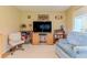 Bright living room features a TV, comfortable seating, and a ceiling fan with a neutral color palette at 7392 Willow Brook Dr, Spring Hill, FL 34606