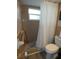 Bathroom features tile shower stall, toilet, and neutral ceramic tile at 7421 Fairfax Dr, Port Richey, FL 34668