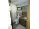 Bathroom with granite-look countertop, toilet, shower, and neutral ceramic tile at 7421 Fairfax Dr, Port Richey, FL 34668