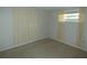 Bedroom with neutral carpet and walls, with an exterior window view at 7421 Fairfax Dr, Port Richey, FL 34668