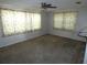 Bedroom featuring neutral carpet, ceiling fan, and two large windows at 7421 Fairfax Dr, Port Richey, FL 34668