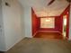 Dining area with a chandelier, red accent wall and light-colored carpet at 7421 Fairfax Dr, Port Richey, FL 34668