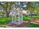 Charming outdoor community bench with decorative pergola and mature trees at 7802 Hardwick Dr # 1116, New Port Richey, FL 34653