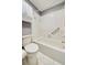 This bathroom has a shower/tub combo, grab bar, white toilet, tiled flooring, and upper cabinet at 7802 Hardwick Dr # 1116, New Port Richey, FL 34653