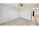 Clean bedroom with hardwood floors, a ceiling fan, and a hallway leading to additional rooms at 7802 Hardwick Dr # 1116, New Port Richey, FL 34653