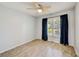 Bright bedroom featuring hardwood floors, a ceiling fan, and natural light from a window with shutters at 7802 Hardwick Dr # 1116, New Port Richey, FL 34653