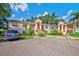 Exterior of a beige condo building with well-manicured landscaping, palm trees, and assigned parking at 7802 Hardwick Dr # 1116, New Port Richey, FL 34653