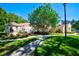 Beautiful exterior shot showing a lush green lawn, mature trees, and a charming building facade at 7802 Hardwick Dr # 1116, New Port Richey, FL 34653