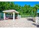 Community outdoor gazebo with shade, a table, and seats near the hot tub at 7802 Hardwick Dr # 1116, New Port Richey, FL 34653