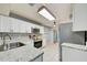 Modern kitchen with white cabinets, granite countertops, stainless steel appliances, and tile flooring at 7802 Hardwick Dr # 1116, New Port Richey, FL 34653