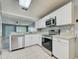 Well-equipped kitchen featuring stainless steel appliances, granite countertops, white cabinetry, and modern backsplash at 7802 Hardwick Dr # 1116, New Port Richey, FL 34653