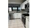 Bright kitchen with stainless steel appliances, white cabinets, stone countertops and tile backsplash at 7802 Hardwick Dr # 1116, New Port Richey, FL 34653