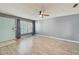 Bright living room featuring wood-look floors, a modern ceiling fan, and plantation-style window shutters at 7802 Hardwick Dr # 1116, New Port Richey, FL 34653