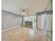 Open-concept living area with wood-look flooring, a ceiling fan, and a partial view of the kitchen at 7802 Hardwick Dr # 1116, New Port Richey, FL 34653
