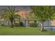 Charming single-story home with a well-manicured lawn, lush landscaping, and beautiful palm tree at 7810 Chalafonte Dr, Port Richey, FL 34668