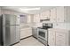Kitchen with stainless steel appliances, light cabinetry, and tile backsplash at 7810 Chalafonte Dr, Port Richey, FL 34668