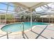 A screened-in pool featuring a ladder and clear water at 7810 Chalafonte Dr, Port Richey, FL 34668