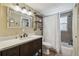 Bright bathroom featuring a vanity with dark wood cabinets and a shower-tub combination at 7830 Ilex Dr, Port Richey, FL 34668