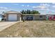 Single-story home featuring a brick facade, attached garage, and a quaint front porch with seating at 7830 Ilex Dr, Port Richey, FL 34668